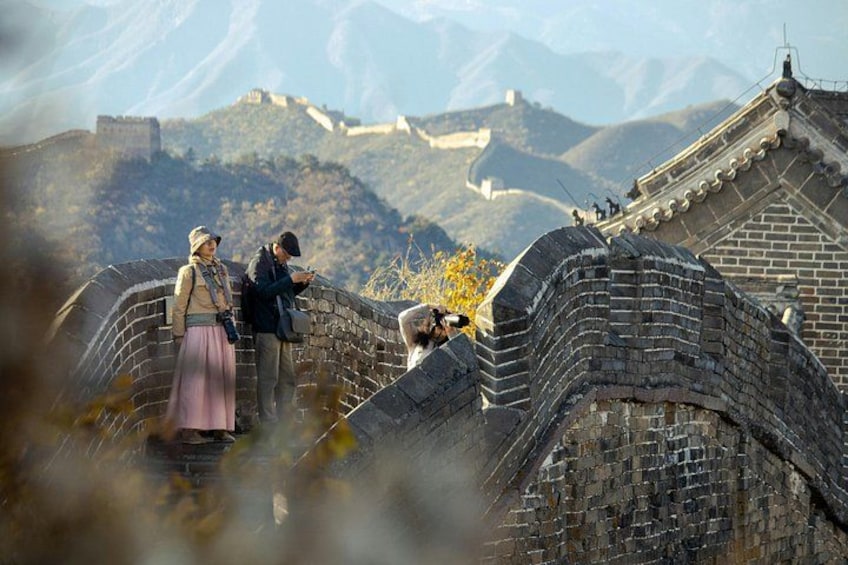 The Great Wall of China, a historic fortification, with people standing and taking photos. 3