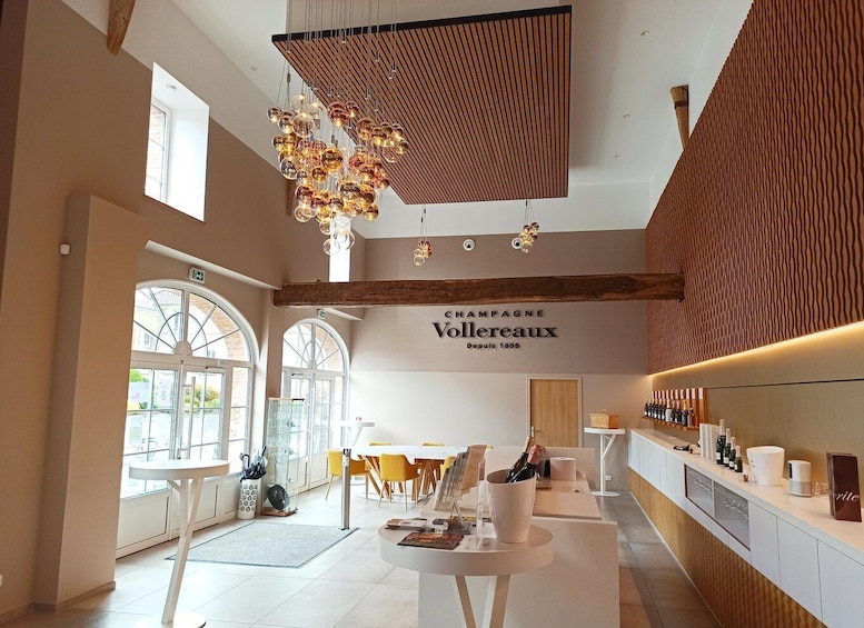 A modern interior with a champagne bar, wooden beams, and a large chandelier. 4
