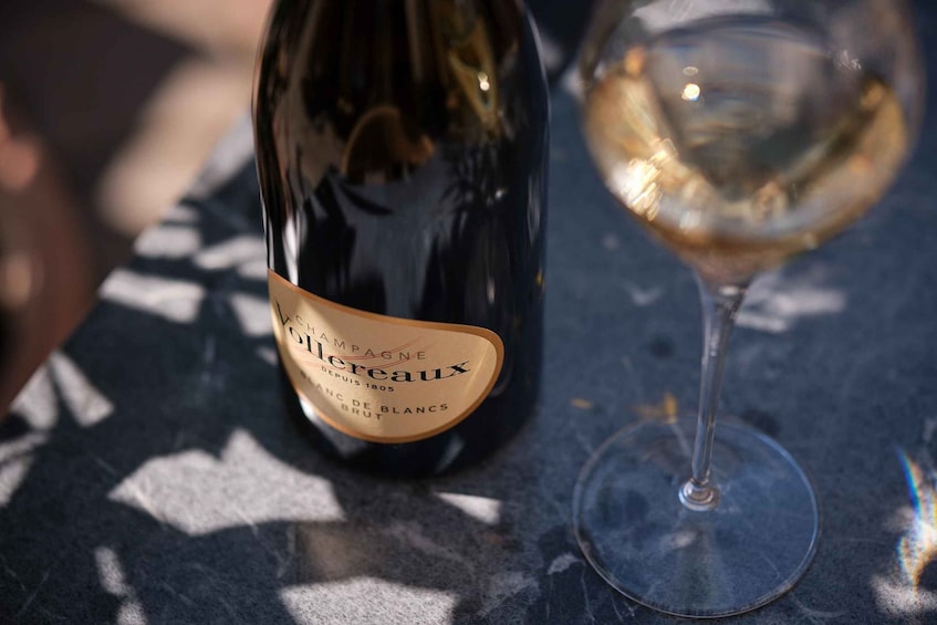 A bottle of champagne and a glass on a table. 5