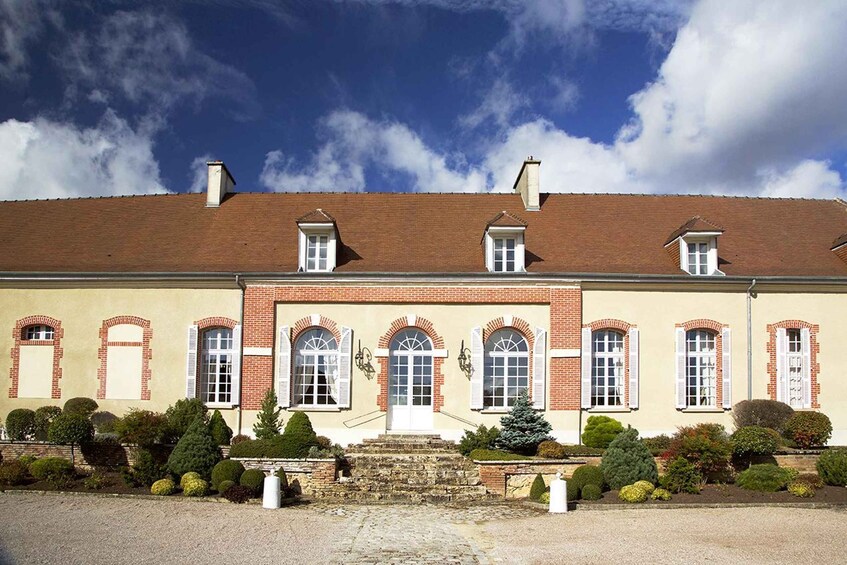 A large, historic building with a symmetrical facade, arched windows, and a central entrance. 2