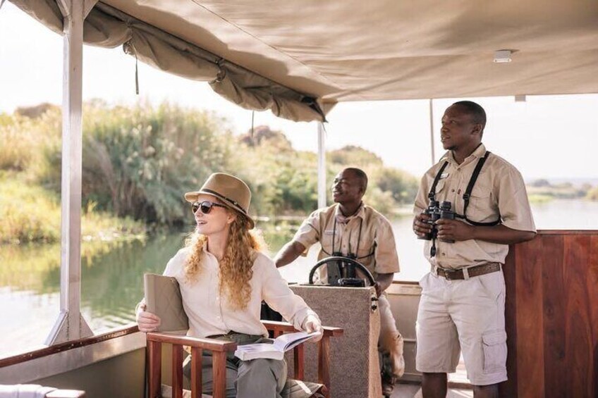 A boat with people on board, a guide with binoculars, and a woman with a laptop. 4