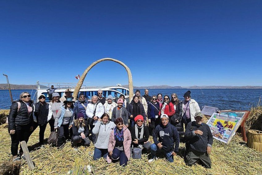 A group of people standing on a dock with a boat in the background. 3