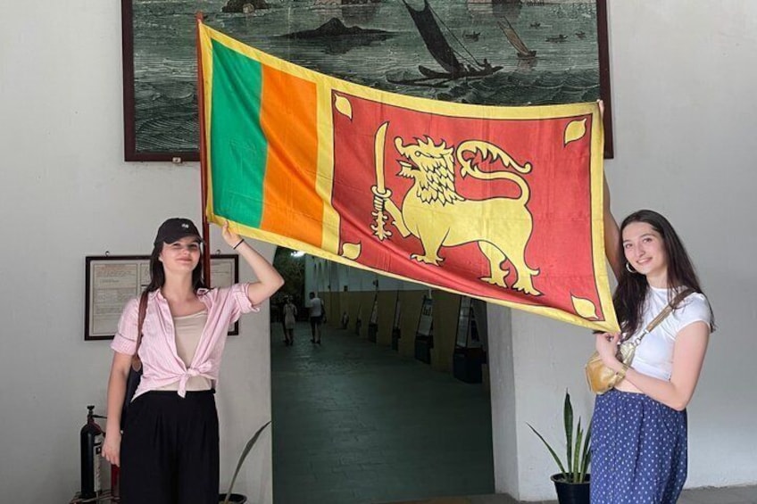 Dos personas sostienen una bandera con un emblema de león. 1