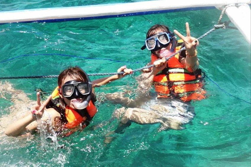 Due persone che fanno snorkeling in piscina, indossando giubbotti di salvataggio e occhialini. 2