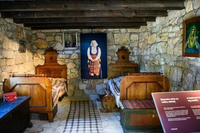 A traditional room with stone walls, wooden furniture, and a painting of a woman. 4