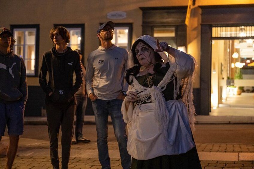 Una persona vestida con traje tradicional camina por una calle de noche. 4