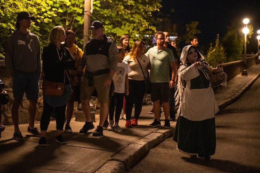 Un grupo de personas en una acera de noche. 1
