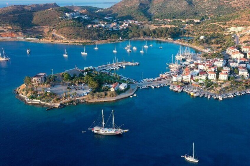 An aerial view of a coastal town with a marina, boats, and buildings. 1