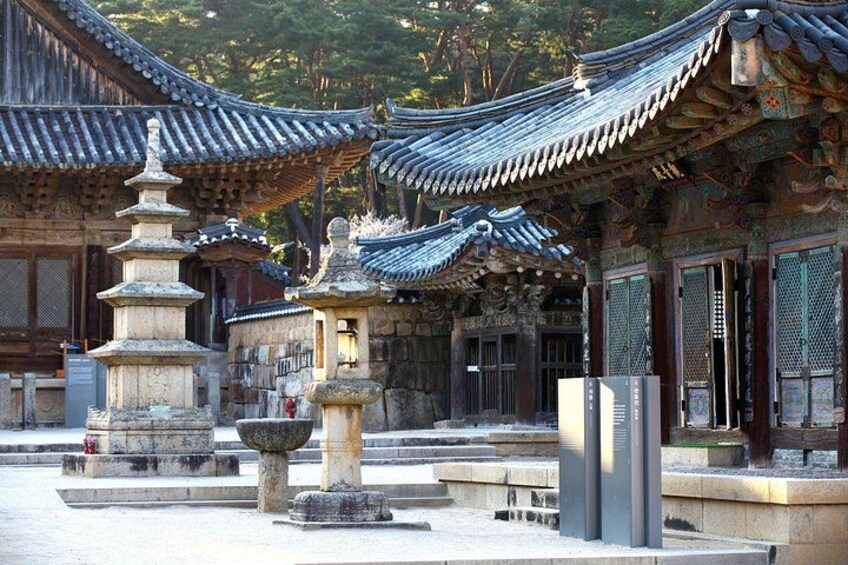 Traditional Korean architecture with ornate roofs and stone lanterns. 2