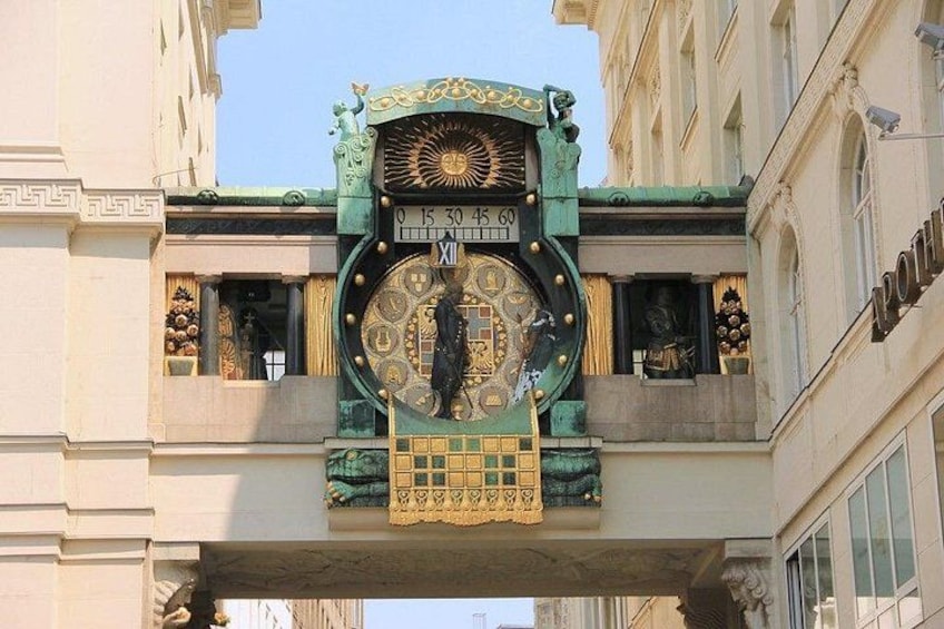 Et stort, udsmykket ur med grønne og gyldne detaljer, monteret på en bygnings facade. 5