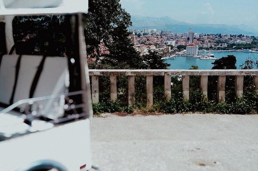 A cityscape with a body of water, a bridge, and a vehicle in the foreground. 3
