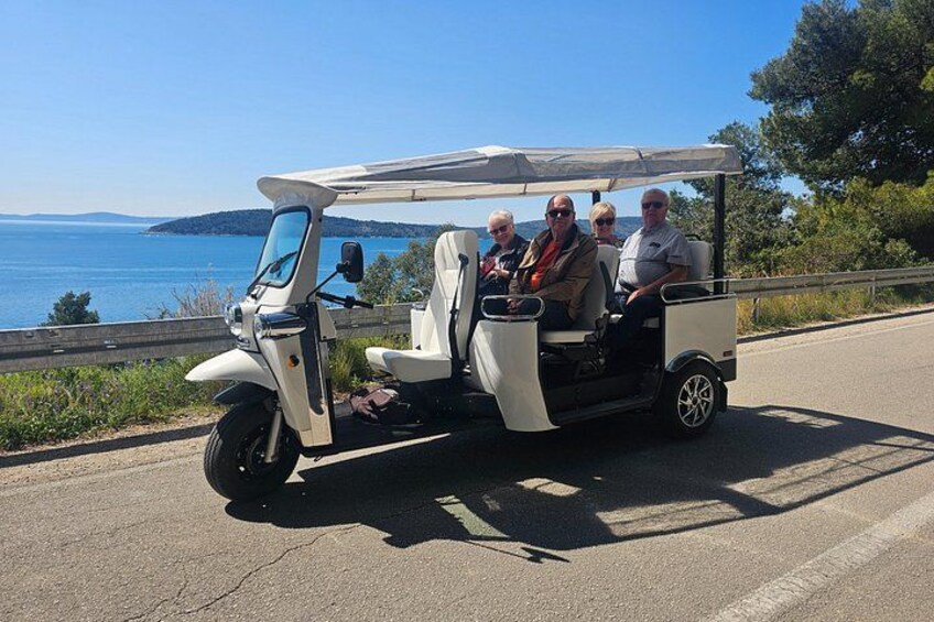 A golf cart on a road with a coastal view. 2
