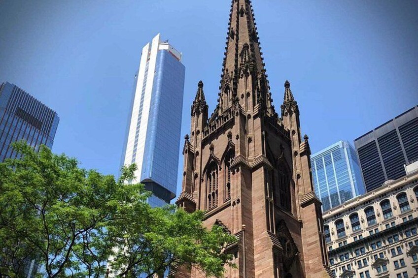 Una iglesia histórica con una aguja alta, rodeada de modernos rascacielos. 4
