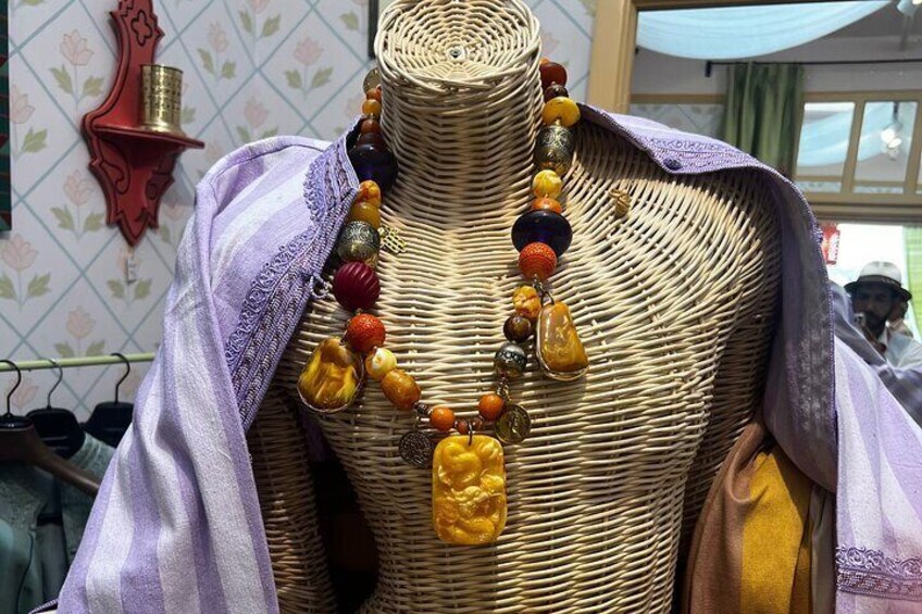 A mannequin with a woven basket-like top and a colorful beaded necklace. 3
