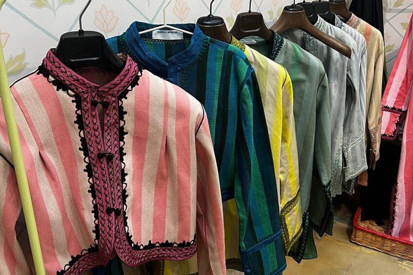 Una estantería con camisetas coloridas a rayas y detalles de encaje. 2