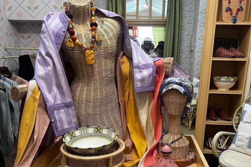 A mannequin dressed in traditional attire with a patterned shawl, a beaded necklace, and a small basket. 5