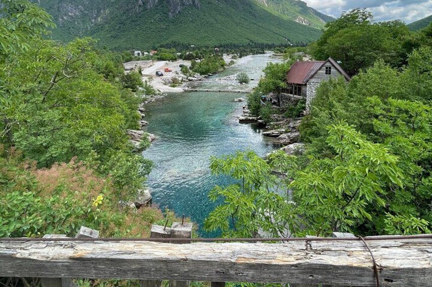 A river flowing through a valley with houses and greenery. 4
