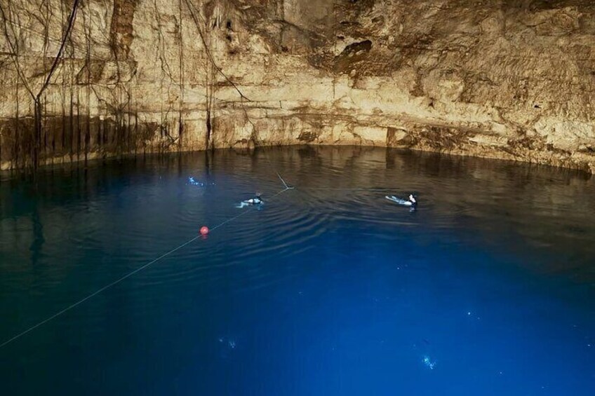 A calm body of water with a red buoy and a person swimming. 2