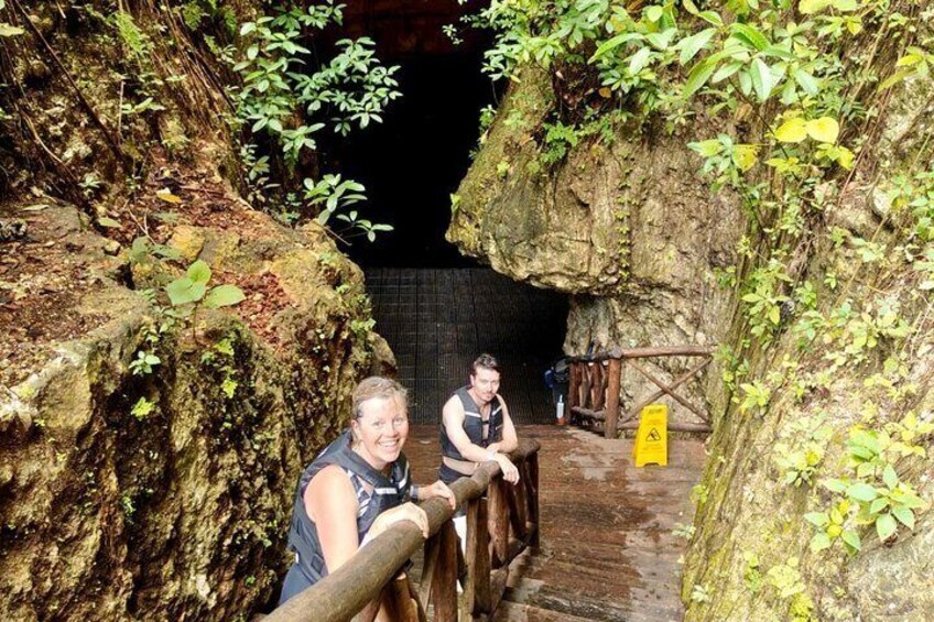 A wooden bridge in a cave with moss-covered rocks and a yellow warning sign. 3