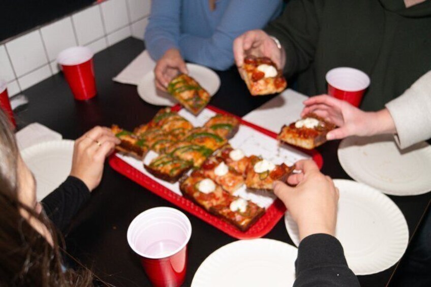 Personer som äter pizza vid ett bord. 3