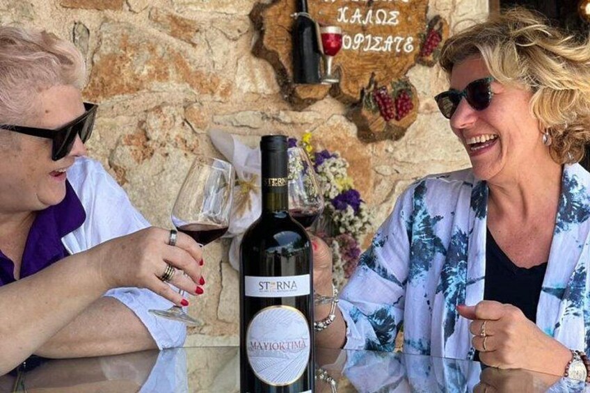 Dos personas sentadas en una mesa con una botella de vino y copas. 5