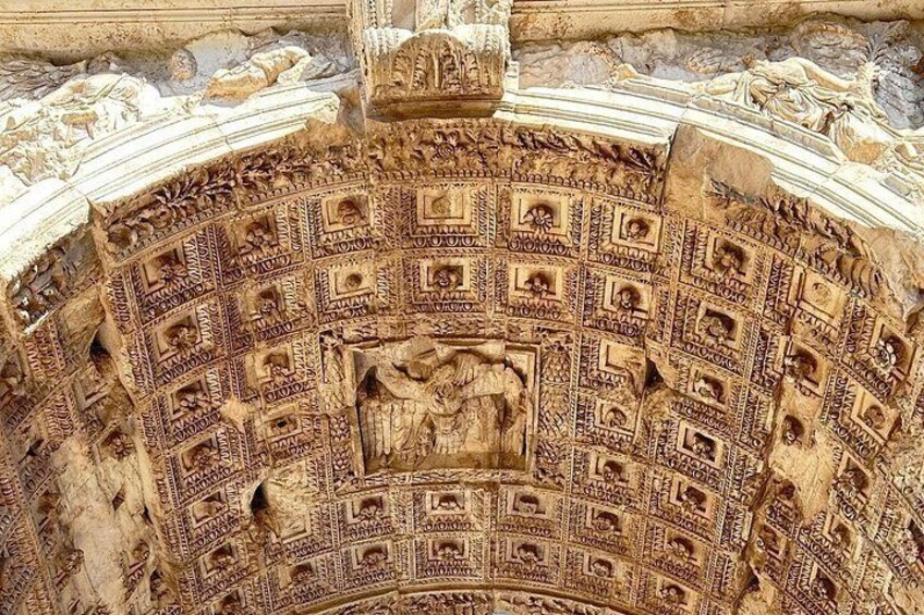 Un plafond en pierre finement sculpté, orné de motifs géométriques et surmonté d’une sculpture en relief centrale. 4