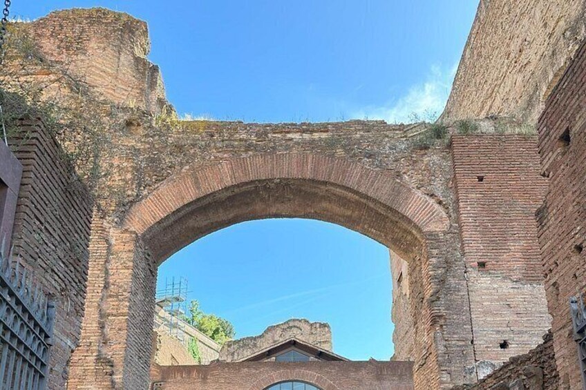 Un arc en briques d’époque, surmonté d’un ciel d’un bleu limpide. 2