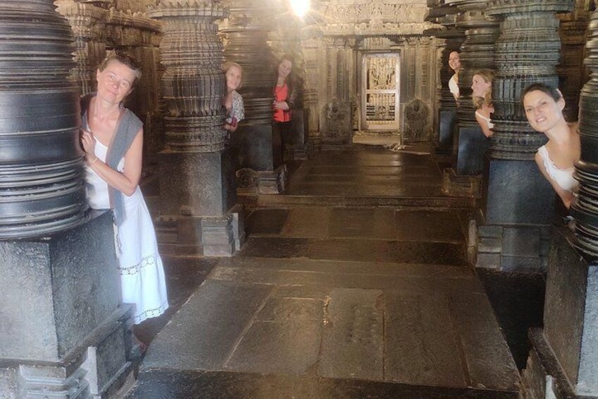 A corridor with stone pillars and a tiled floor. 2