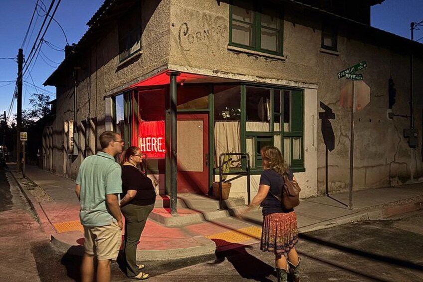 A street scene with a building labeled 'Cafe' and a sign reading 'HERE'. 3