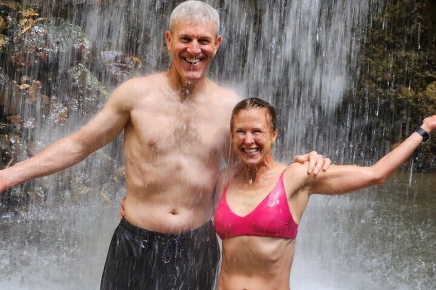 A man and a woman standing in front of a waterfall. 5