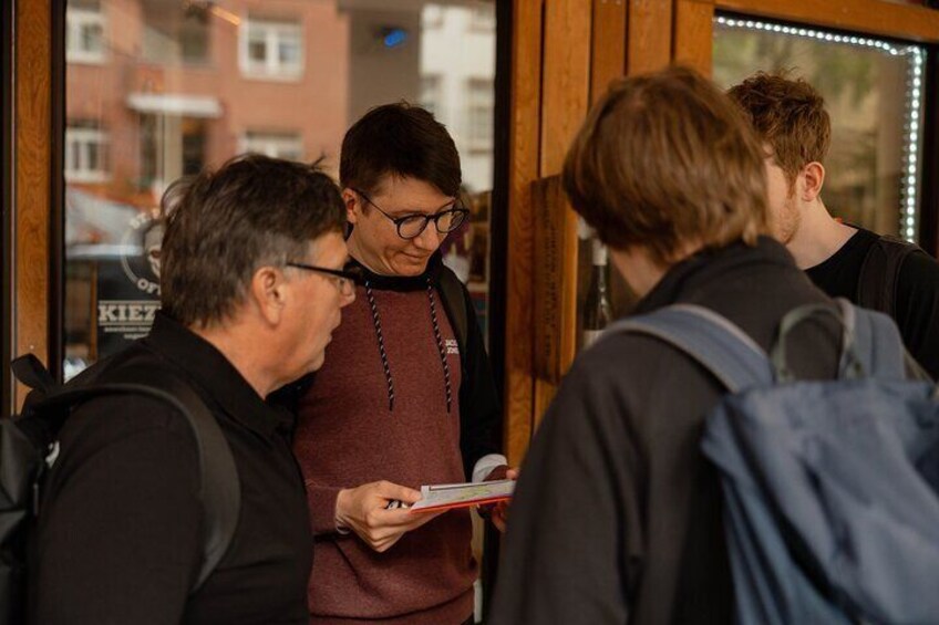 Een groep mensen staat bij de balie in een café. 5