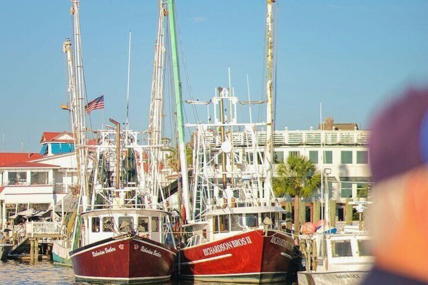 A marina with several boats docked, including a red boat named 'Richmond Bridge II'. 4