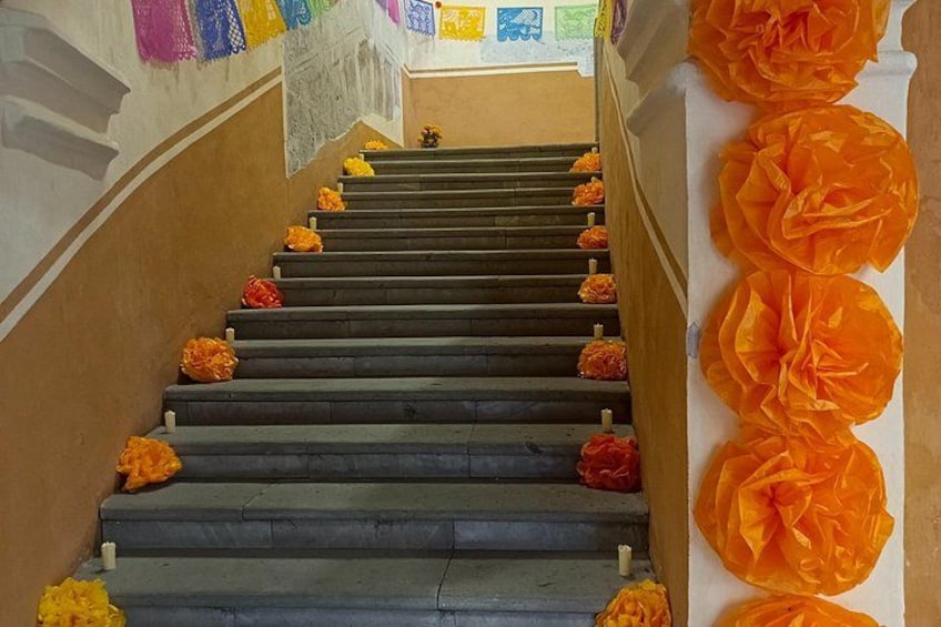 En trappe med orange blomster og et muralmaleri. 2