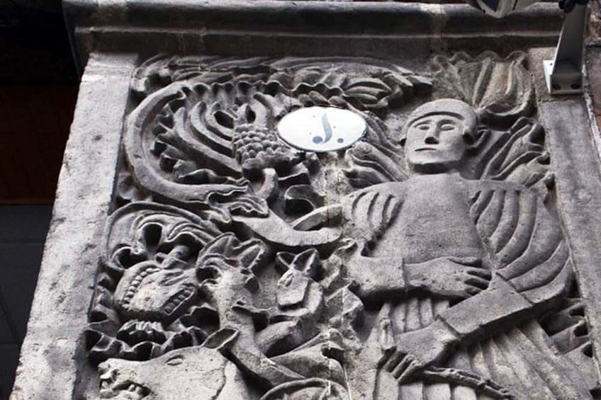 En stentavle med detaljerede dragemotiver og en menneskelig figur. 4