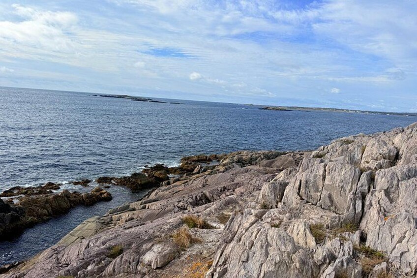 A rocky coastline with calm sea and clear sky. 2