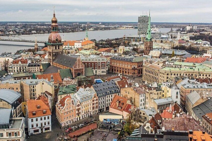 A cityscape with historic buildings, a prominent church with a dome, and a river in the background. 1