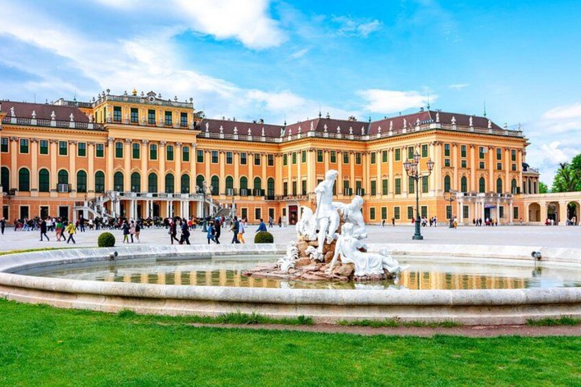 A large classical building with a fountain in front. 2