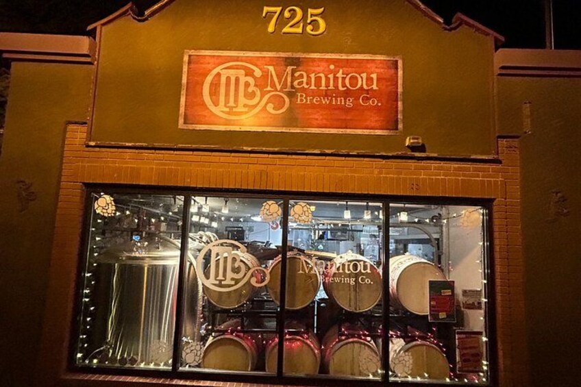 A building with a sign reading 'Manitou Brewing Co.' and the number '725' above it. 1