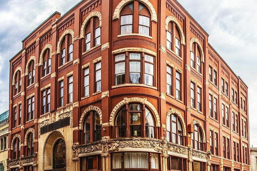 Un edificio in mattoni rossi con finestre ad arco e decorazioni elaborate. 1