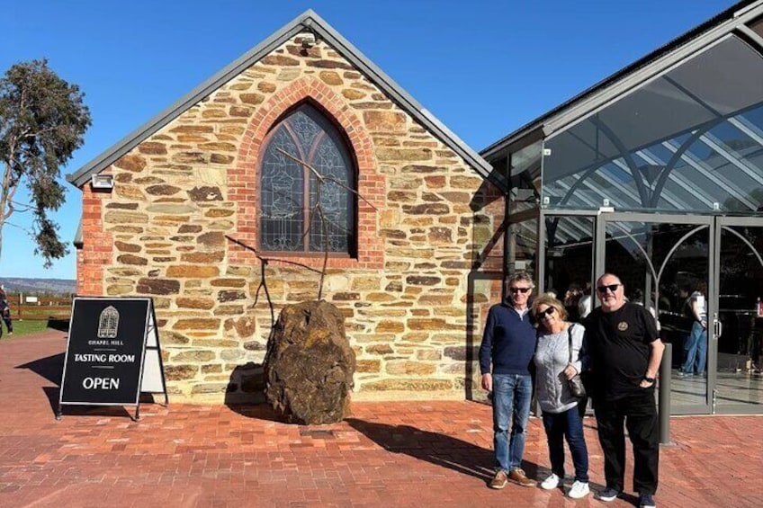 En bygning i sten med et stort vindue og et skilt, der siger "Tasting Room ÅBEN". 5