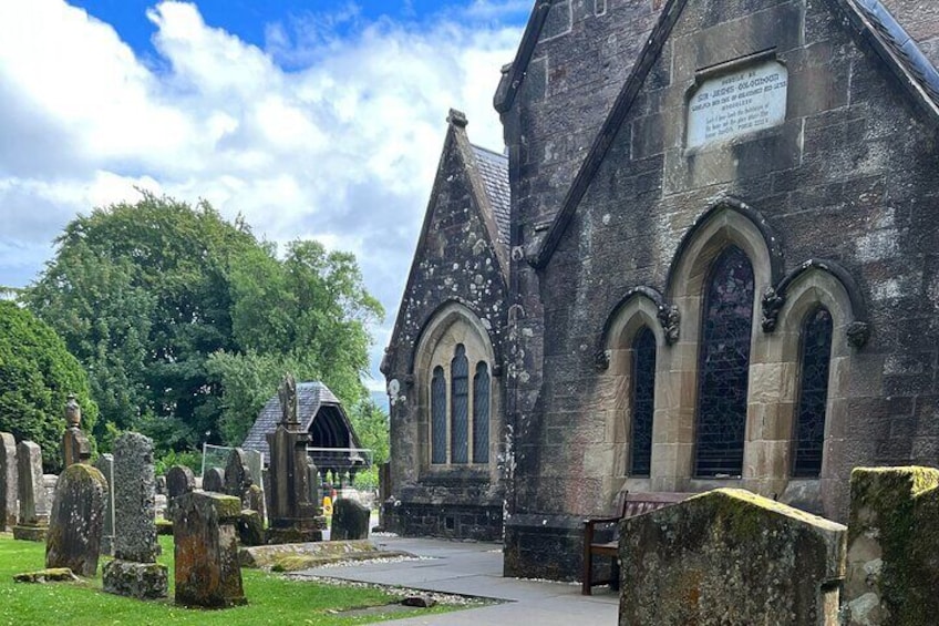 Una iglesia histórica con arcos apuntados y campanario, rodeada por un cementerio con lápidas. 4