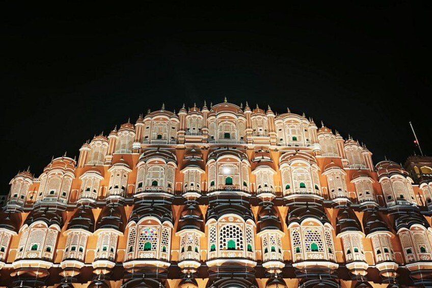 A brightly lit, ornate building with multiple balconies and intricate architectural details. 2