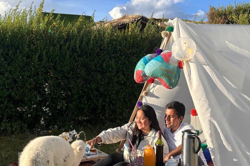 A tent with a white interior, a person holding a drink, and a white fluffy animal in the foreground. 5