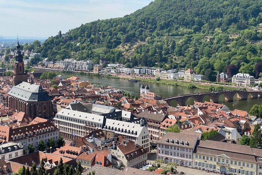 A river flowing through a town with historic buildings and a bridge. 4
