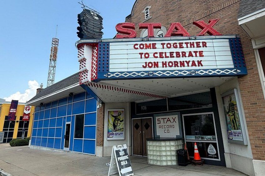 A theater with a marquee reading 'STAX COME TOGETHER TO CELEBRATE JON HORNYAK.' 5