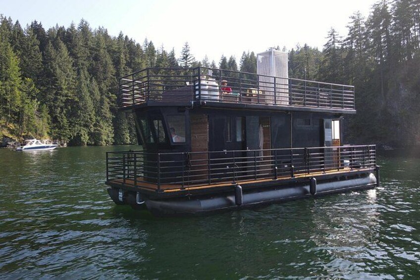 Une péniche est amarrée sur un lac paisible, entouré d’une forêt dense. 1
