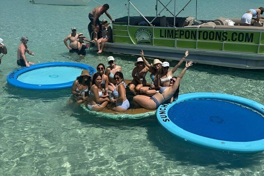 Een groep mensen op een drijvend platform met opblaaszwembaden in het water. 2
