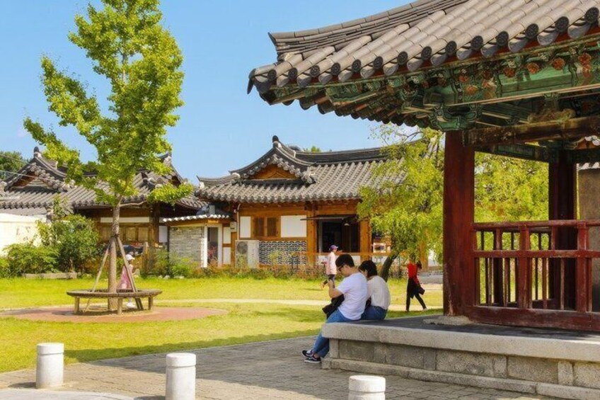 Traditional Korean architecture with a pavilion and a tree in a park. 5