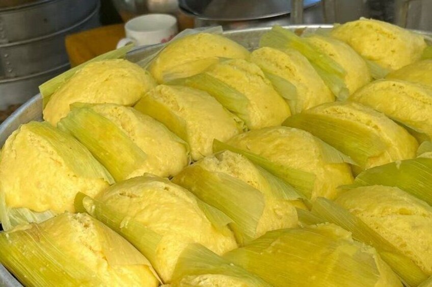 Eine Schale mit Tamales, eingewickelt in Maisblätter. 3