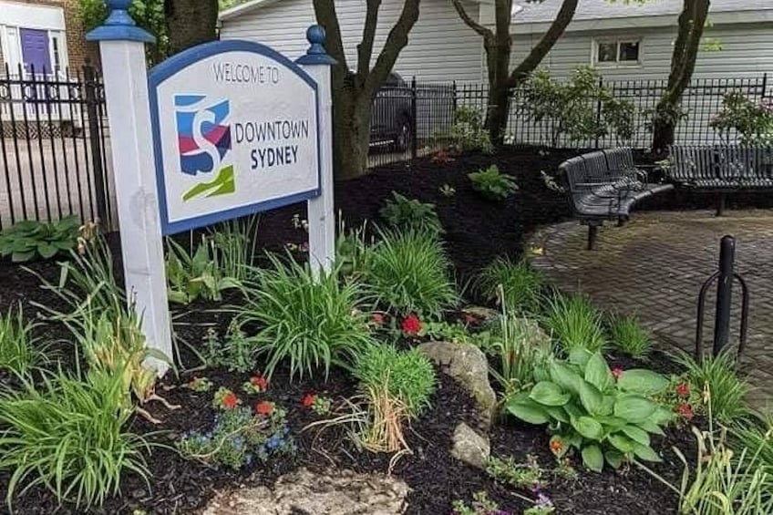 A welcome sign for Downtown Sydney with a landscaped garden in front. 5